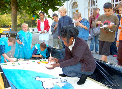 Rhode Makoumbou et les élèves de l'École communale d'Ixelles réalisant une peinture intitulée «Un pas vers la Paix»