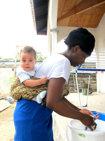 Rhode Makoumbou portant son fils Quentin et en plein travail de lessive !
